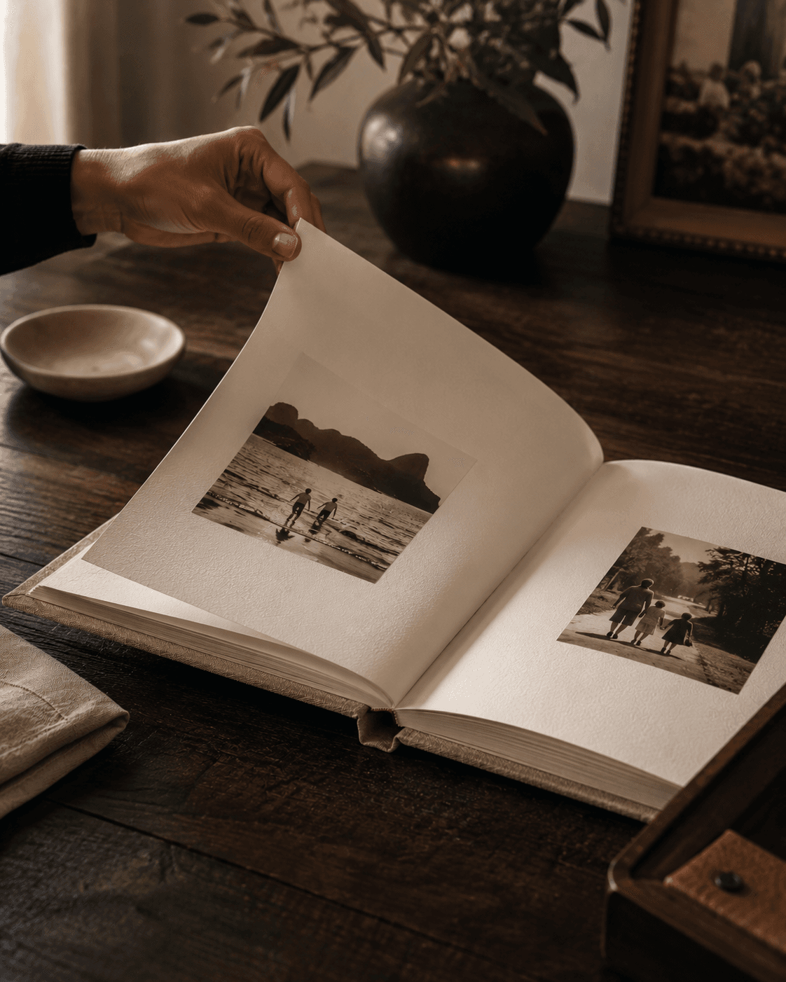 Livro de memórias aberto sobre uma mesa de madeira com fotografias em tons sépia.